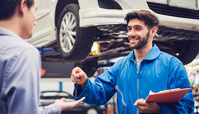 Car mechanic handing over keys